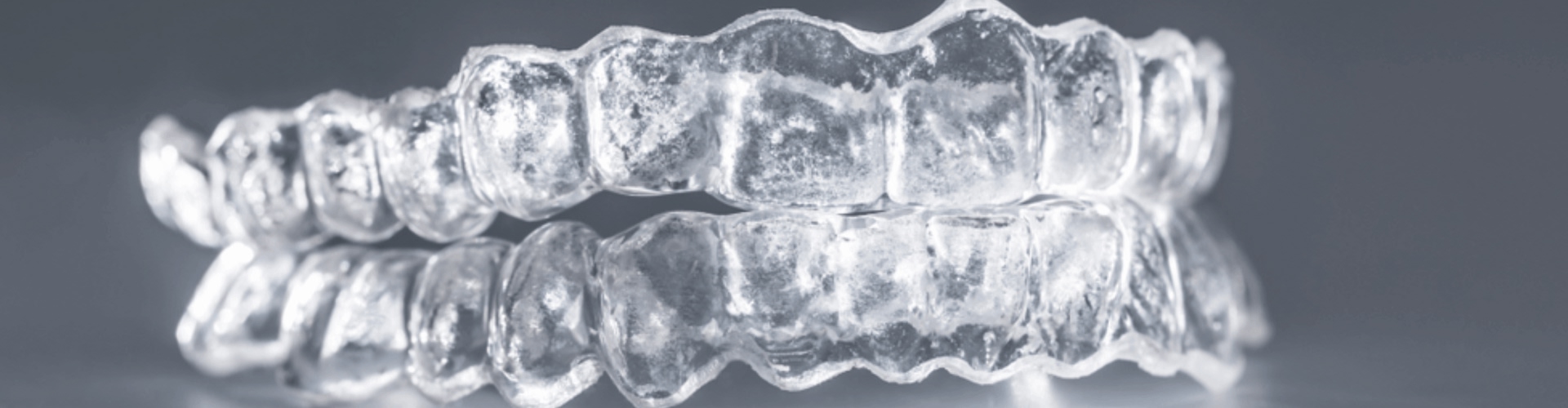 Pair of clear aligners on a surface.
